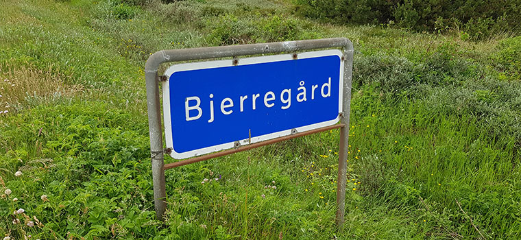 Blaues Ortsschild bei Bjerregard