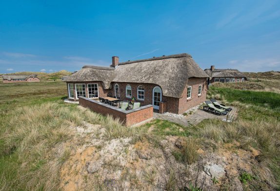 Ferienhaus mit Reetdach und Aussicht auf die Dünen